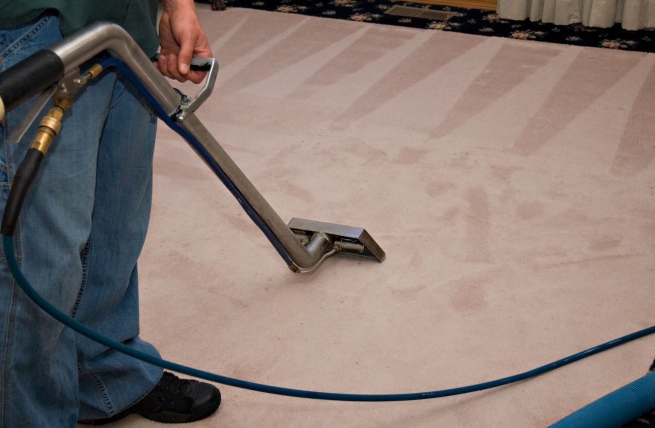 Deep Carpet Restoration for Lasting Freshness A person cleans a carpet with a vacuum, highlighting a restoration service located in Los Angeles, CA.